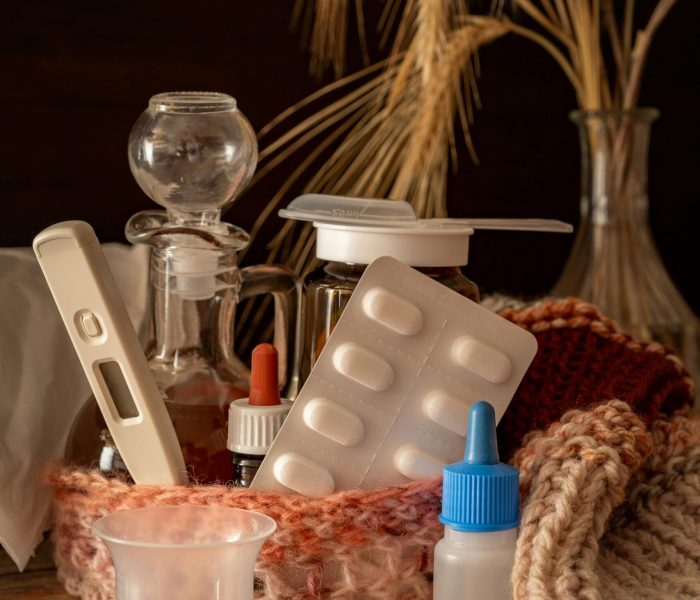 A collection of medications and knitwear arranged with autumn accents, conveying warmth and healing.