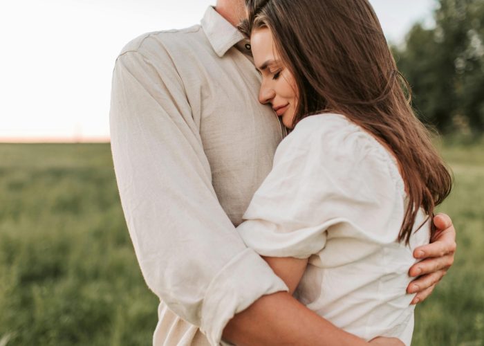 A romantic embrace between a couple outdoors at sunset, showcasing love and connection.